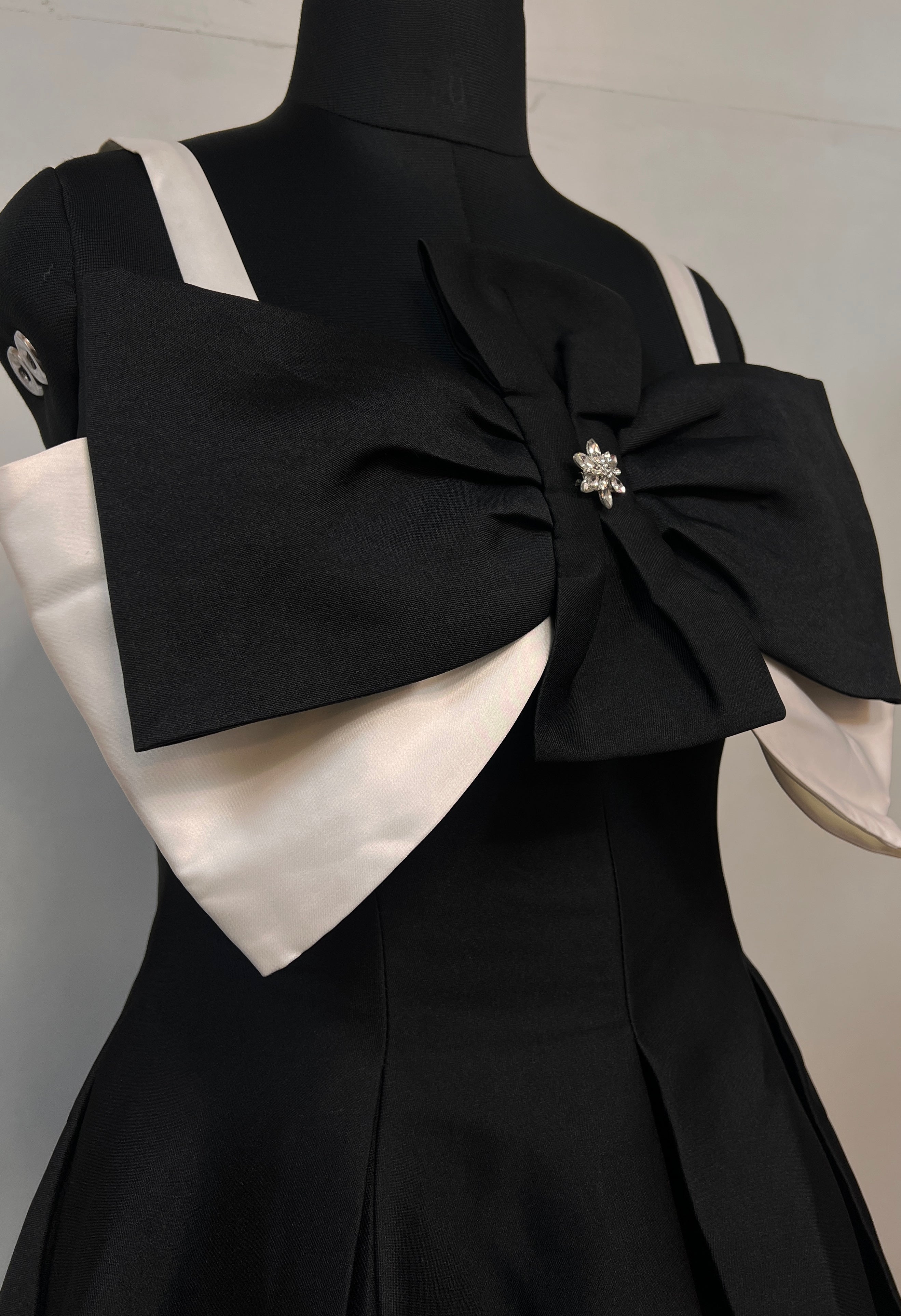 Black bodice with embellished center pin and oversized bow detail