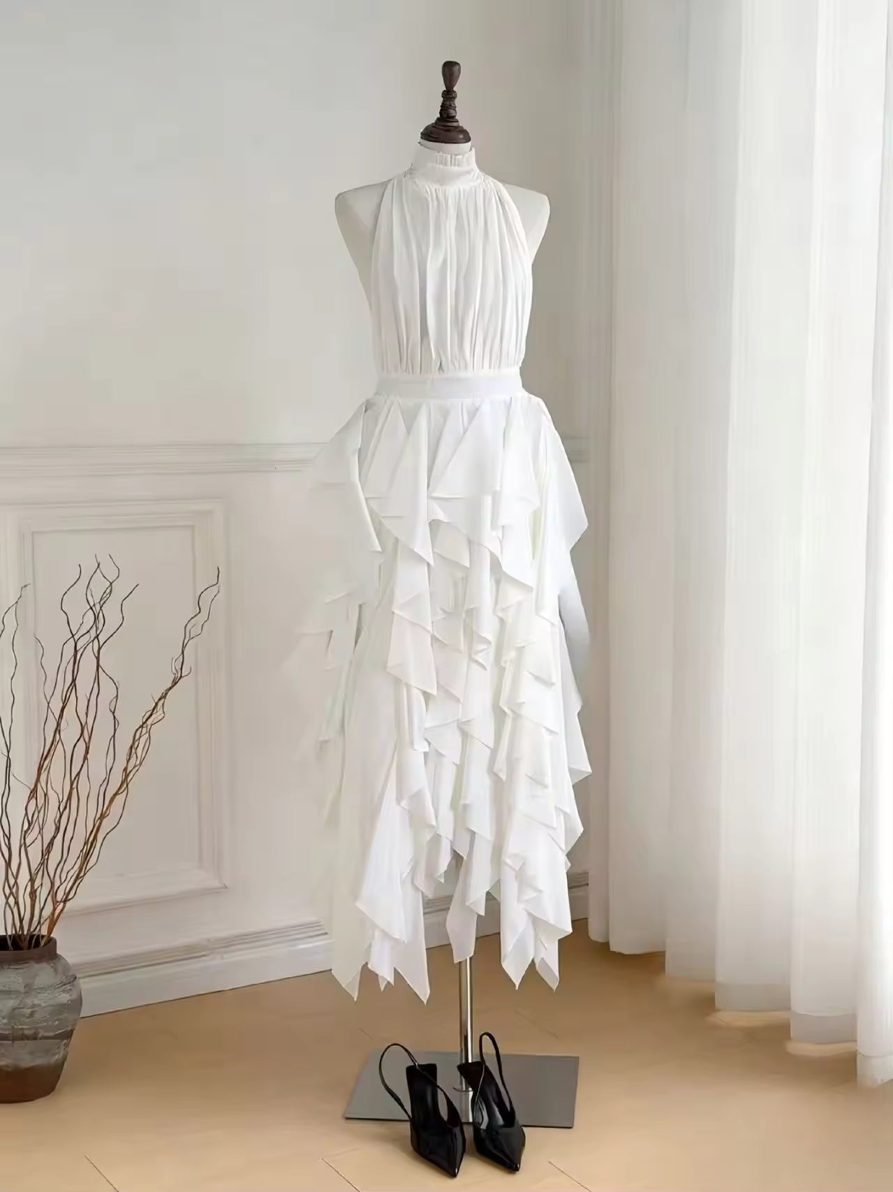 White halter ruffle midi dress on mannequin with tiered cascading skirt